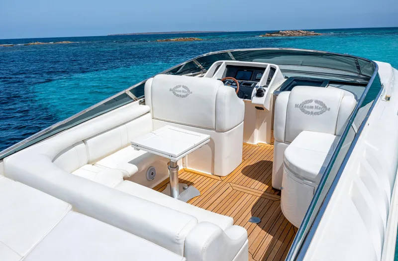 White Chocolate Yacht Photos Pics Luxurious 2003 Magnum 44 yacht interior with white seating, wooden deck, and ocean view.