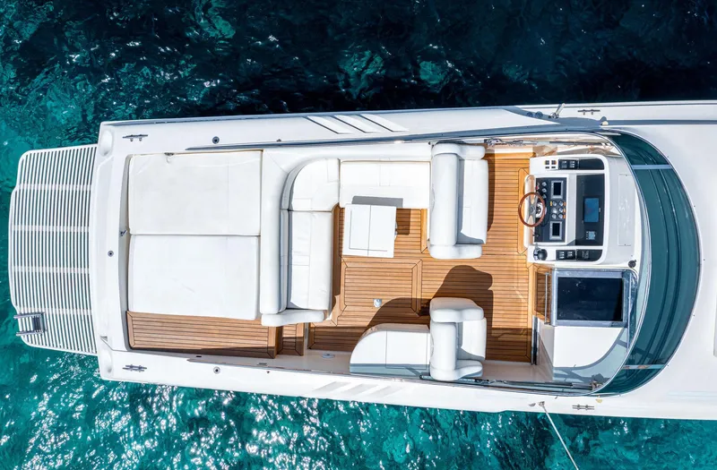 White Chocolate Yacht Photos Pics Top view of a 2003 Magnum 44 yacht with white seating and wooden deck.