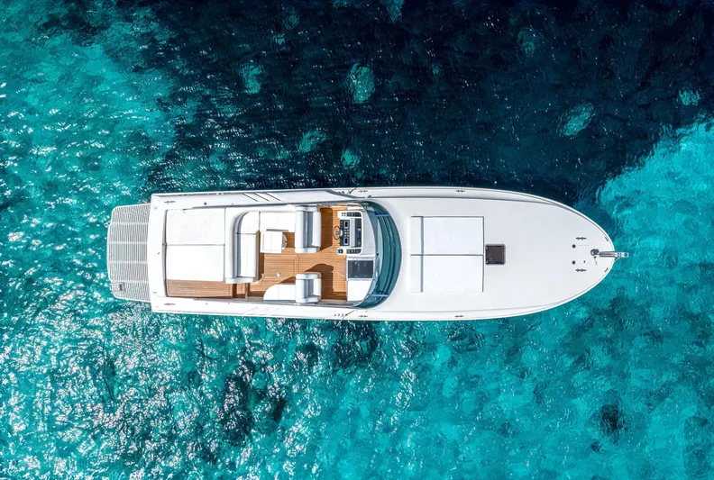 White Chocolate Yacht Photos Pics Aerial view of 2003 Magnum 44 yacht on clear blue water.