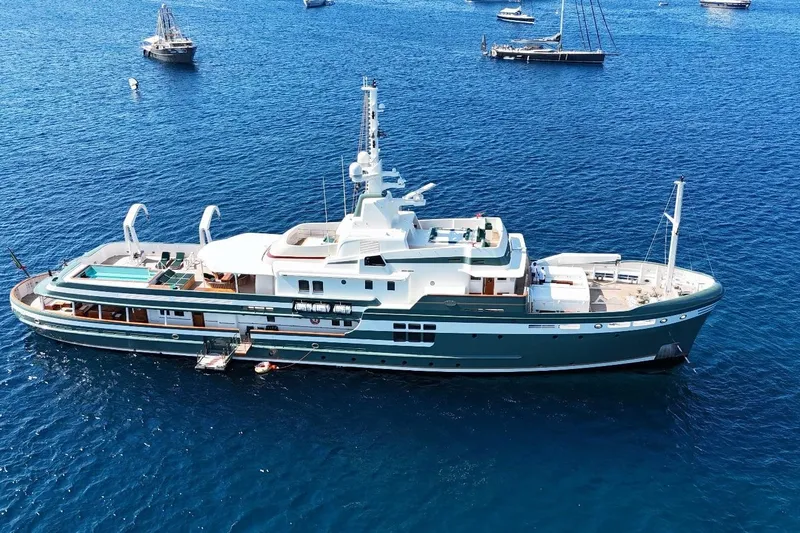 Steel Yacht Photos Pics Luxurious 2009 Pendennis 55 yacht on serene blue waters, surrounded by other boats.