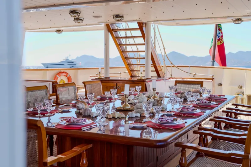Steel Yacht Photos Pics Luxurious dining setup on Pendennis 55 yacht, 2009 model, with ocean and mountain views.