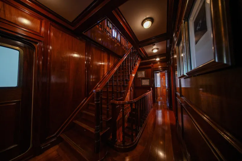 Steel Yacht Photos Pics Luxurious wooden interior of 2009 Pendennis 55 yacht, featuring elegant staircase and polished walls.