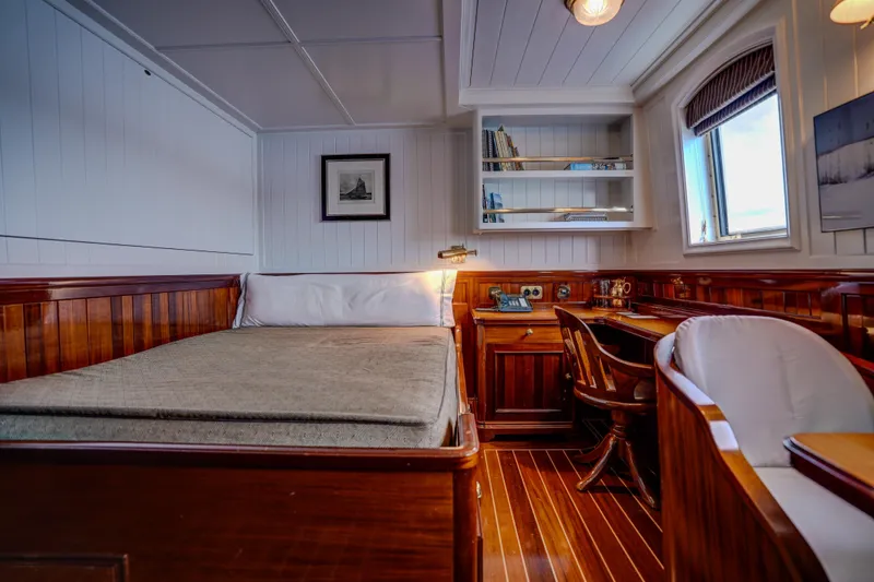 Steel Yacht Photos Pics Luxurious Pendennis 55 yacht cabin interior, featuring elegant wood paneling and a cozy workspace.