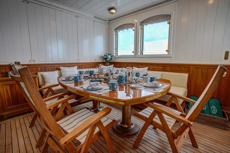 Steel Yacht Photos Pics Luxurious dining area on 2009 Pendennis 55 yacht with elegant wooden furniture and table setting.