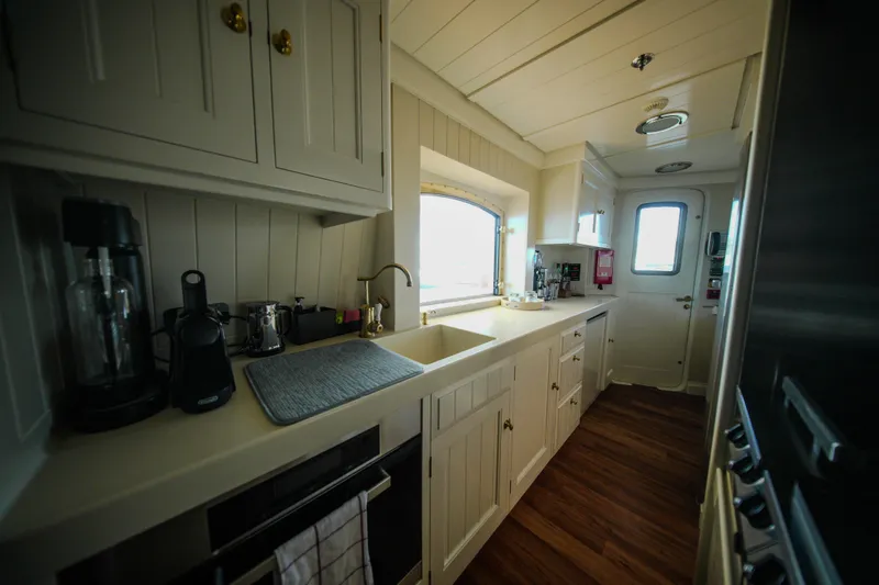 Steel Yacht Photos Pics Luxurious kitchen interior of 2009 Pendennis 55 yacht with modern appliances and wooden flooring.