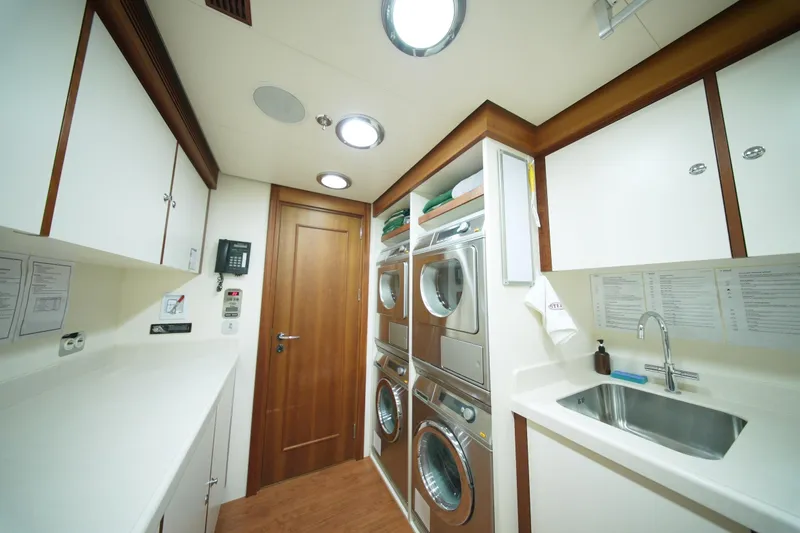 Steel Yacht Photos Pics Laundry room on Pendennis 55 yacht, featuring modern appliances and sleek cabinetry, 2009 model.