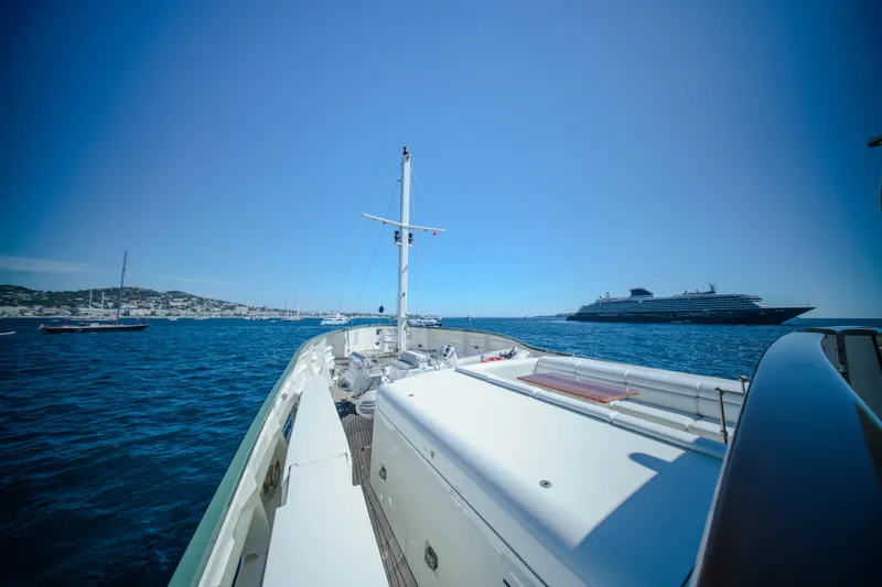 Steel Yacht Photos Pics Pendennis 55 yacht cruising in blue waters, 2009 model, with distant ships and coastline.