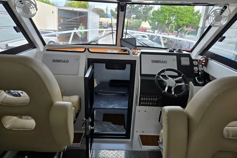  Yacht Photos Pics Interior of 2025 Custom Boat 34, featuring dual Simrad displays and comfortable seating.