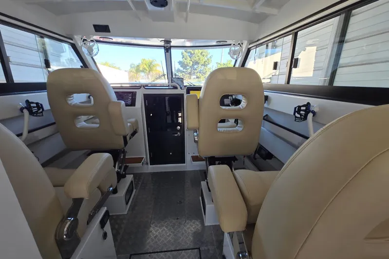  Yacht Photos Pics Interior of 2025 Custom Boat 34, featuring beige seating and modern controls.