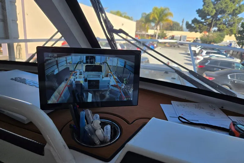  Yacht Photos Pics Interior view of 2025 Custom Boat 34 with navigation screen and parked cars outside.
