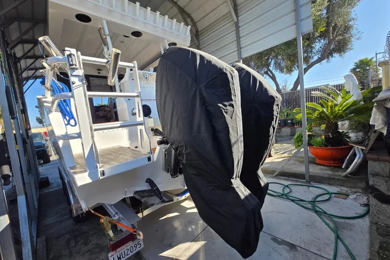  Yacht Photos Pics 2025 Custom Boat 34 with covered outboard motors in a sheltered area.