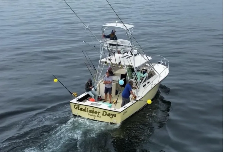 Yacht Photos Pics 2005 Carolina Classic 28 boat, "Gladiator Days," with people fishing in open water.