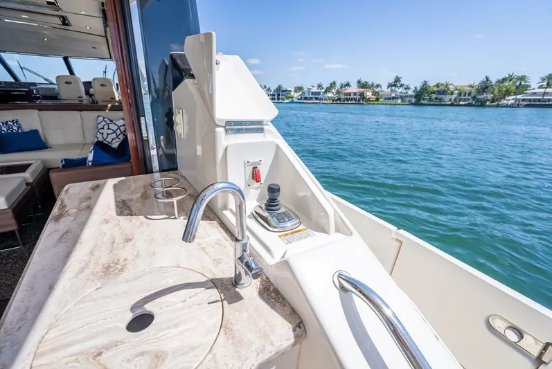  Yacht Photos Pics Luxurious 2016 Sea Ray L650 Fly yacht deck with sink and controls, overlooking serene waters.