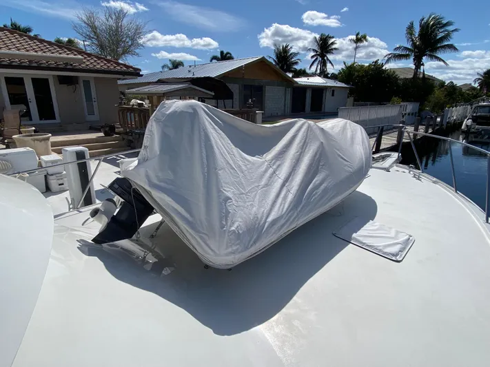 Mad East Yacht Photos Pics Covered boat on a 1993 Hatteras 54 Convertible yacht, docked near waterfront homes.