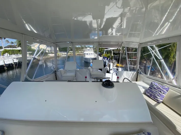 Mad East Yacht Photos Pics Interior view of a 1993 Hatteras 54 Convertible yacht with seating and clear windows.