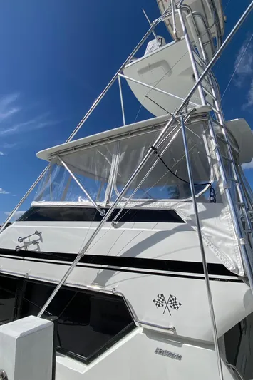 Mad East Yacht Photos Pics 1993 Hatteras 54 Convertible yacht with tower against blue sky.