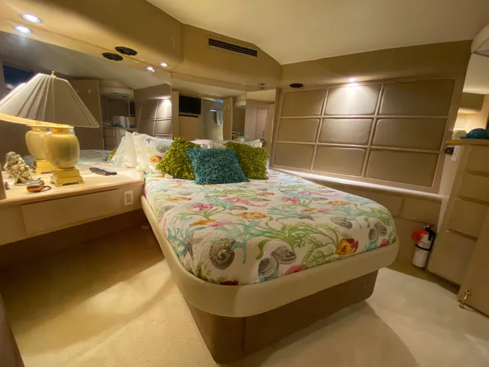 Mad East Yacht Photos Pics Luxurious bedroom interior of 1993 Hatteras 54 Convertible yacht with elegant decor.