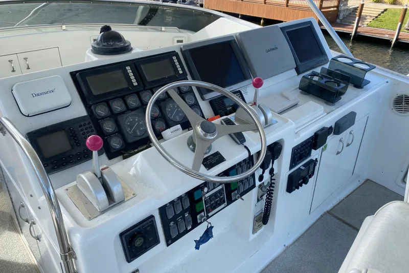 Mad East Yacht Photos Pics 1993 Hatteras Convertible yacht helm with steering wheel and navigation controls.