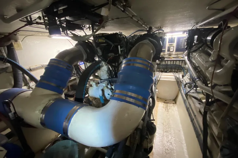 Mad East Yacht Photos Pics Engine room of 1993 Hatteras Convertible yacht with visible pipes and machinery.