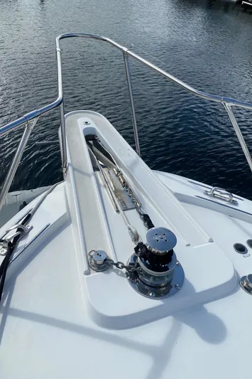 Mad East Yacht Photos Pics 1993 Hatteras Convertible yacht bow with anchor winch on calm water.