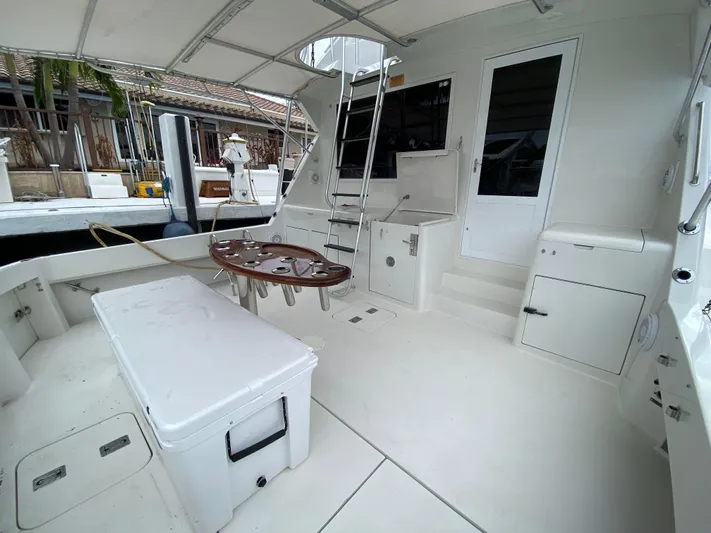 Mad East Yacht Photos Pics 1993 Hatteras Convertible yacht interior with seating, table, and ladder.