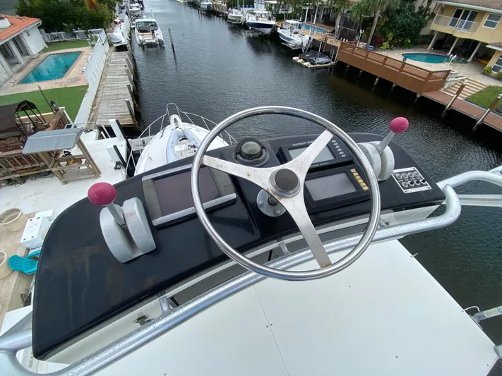 Mad East Yacht Photos Pics 1993 Hatteras Convertible yacht helm with dual controls and waterway view.