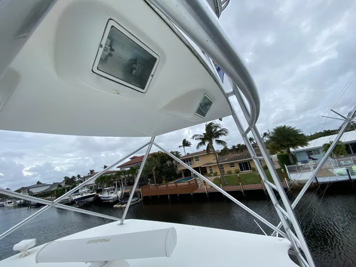 Mad East Yacht Photos Pics 1993 Hatteras Convertible boat docked by waterfront homes under cloudy skies.