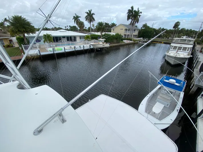 Mad East Yacht Photos Pics 1993 Hatteras Convertible yacht docked in a scenic canal with palm trees.