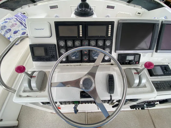 Mad East Yacht Photos Pics 1993 Hatteras Convertible boat helm with steering wheel, controls, and navigation equipment.
