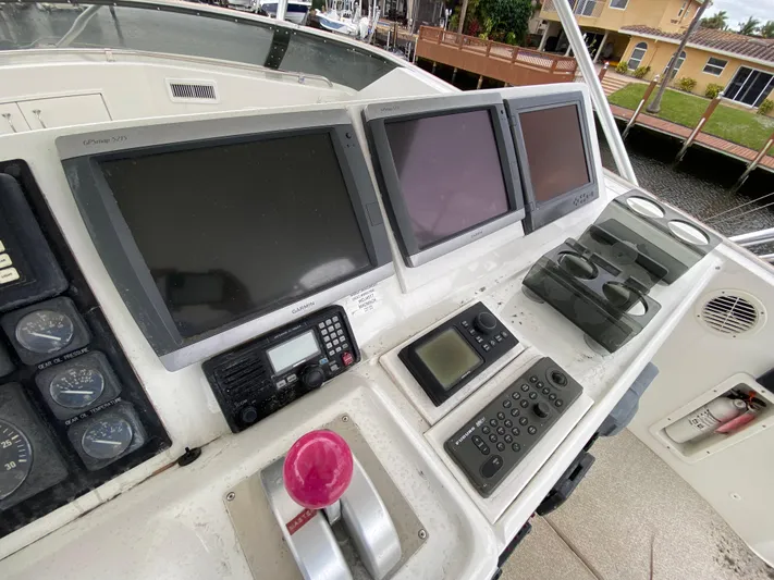 Mad East Yacht Photos Pics Control panel of a 1993 Hatteras Convertible boat with multiple screens and navigation equipment.