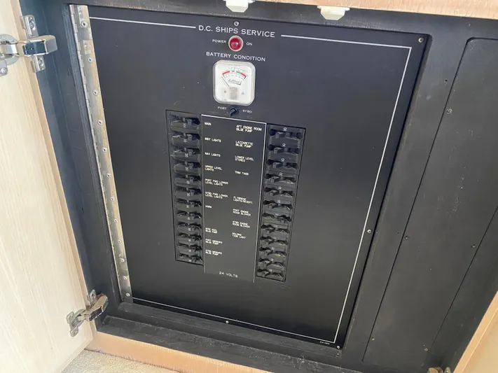 Mad East Yacht Photos Pics Electrical panel on a 1993 Hatteras Convertible boat, showing circuit breakers and battery condition gauge.