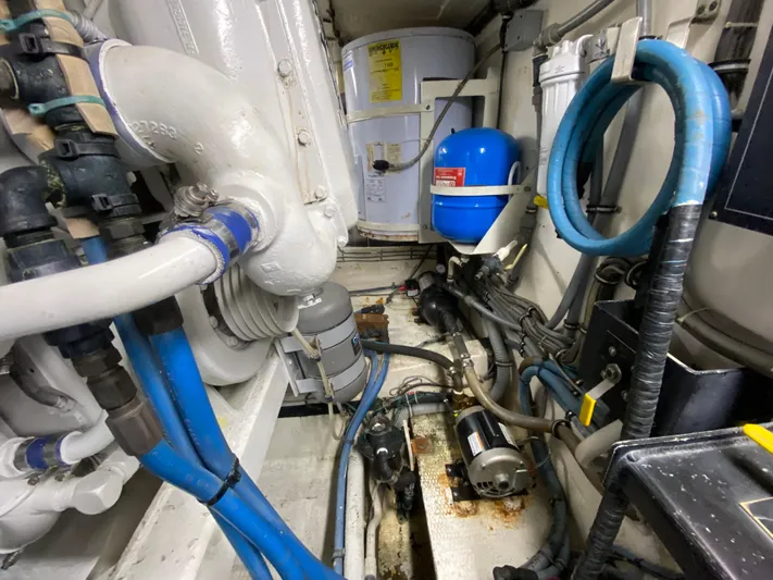 Mad East Yacht Photos Pics Engine room of 1993 Hatteras Convertible boat with pipes and machinery.