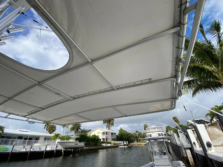 Mad East Yacht Photos Pics 1993 Hatteras Convertible boat canopy with waterfront view and palm trees.