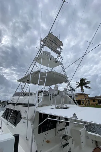 Mad East Yacht Photos Pics 1993 Hatteras Convertible yacht with tower against cloudy sky.