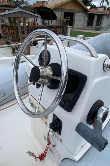 Mad East Yacht Photos Pics Steering wheel of a 1993 Hatteras Convertible boat with control panel.
