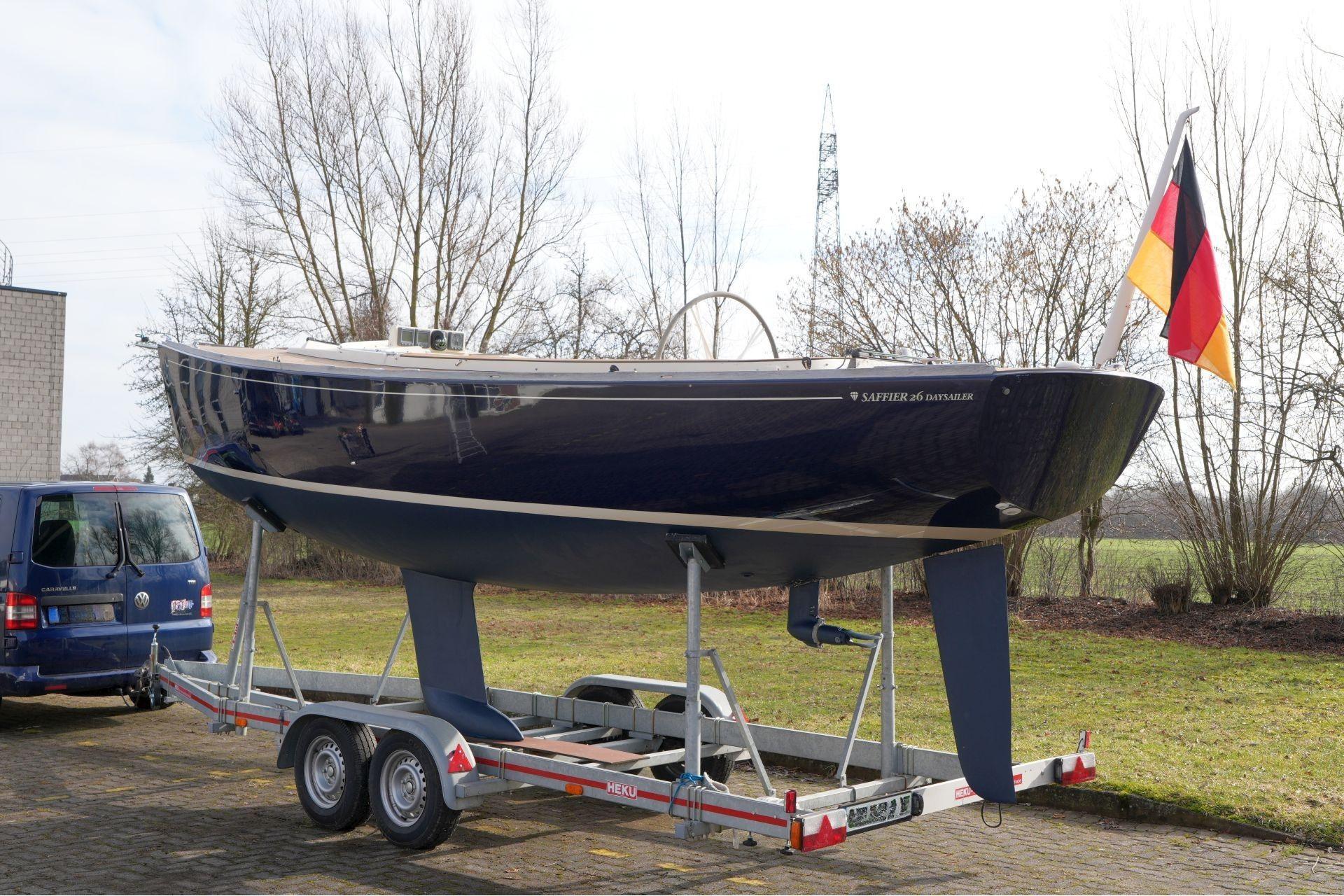 Saffier Se 26 sailboat on trailer, 2010 model, with German flag, parked outdoors.
