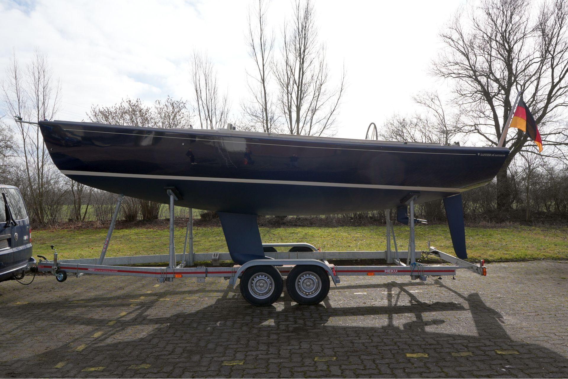 2010 Saffier Se 26 sailboat on trailer with German flag, parked outdoors.