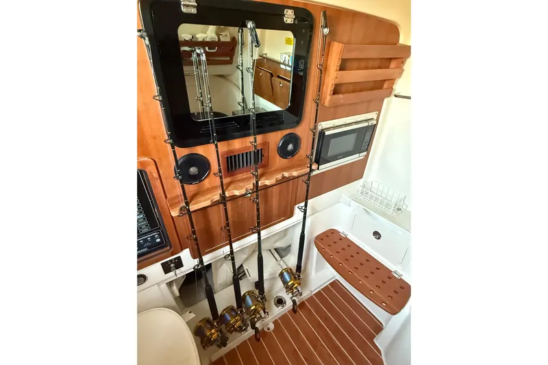 376-420 Brokerage Tyler Yacht Photos Pics 2020 Grady-White Canyon 376 interior with fishing rods and wooden accents.