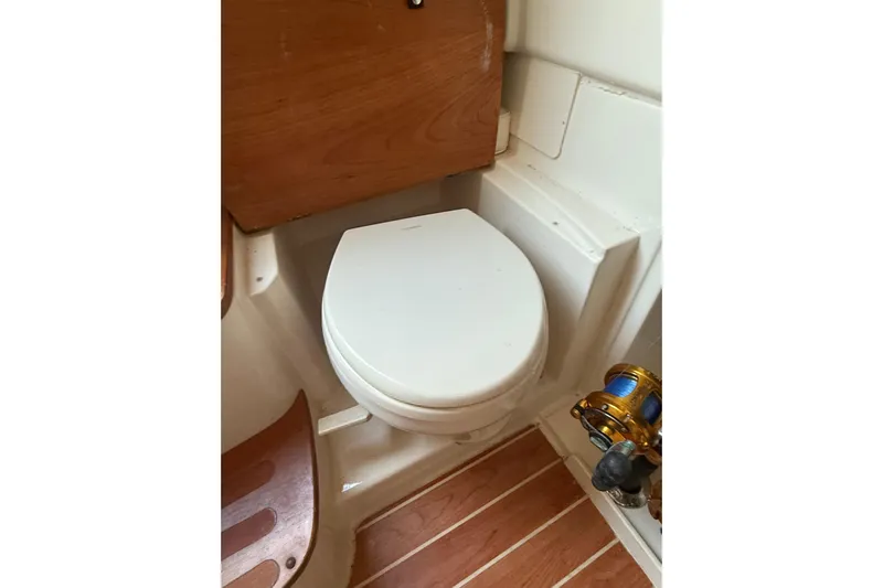 376-420 Brokerage Tyler Yacht Photos Pics 2020 Grady-White Canyon 376 boat toilet with wooden flooring and fishing reel.