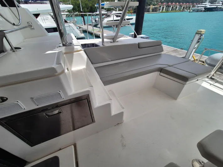 Takamaka Yacht Photos Pics Leopard 50 yacht deck with seating, docked by turquoise water, 2020 model.