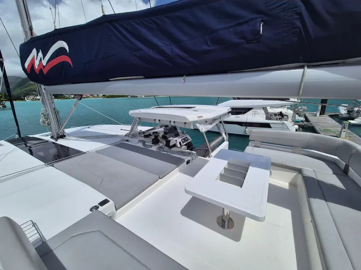 Takamaka Yacht Photos Pics Leopard 50 catamaran deck with seating and table, docked in a marina, 2020 model.