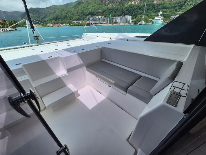 Takamaka Yacht Photos Pics Leopard 50 yacht cockpit with seating, overlooking scenic marina and lush mountains, 2020 model.