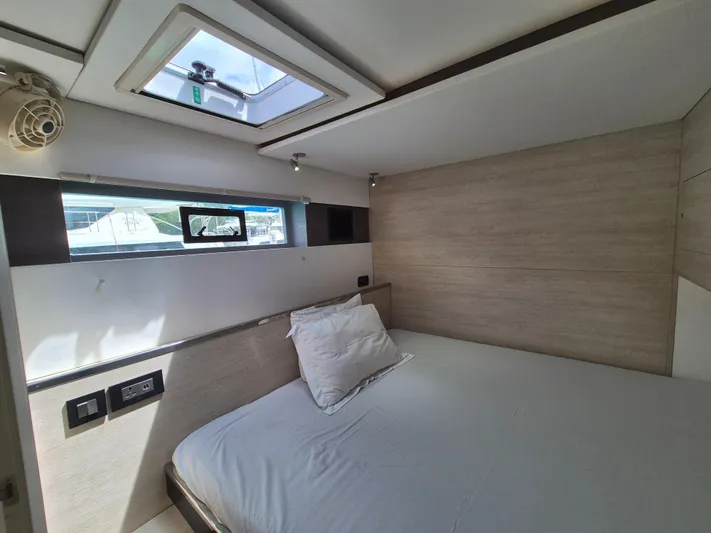 Takamaka Yacht Photos Pics Modern bedroom interior in a 2020 Leopard 50 yacht, featuring a skylight and minimalist design.