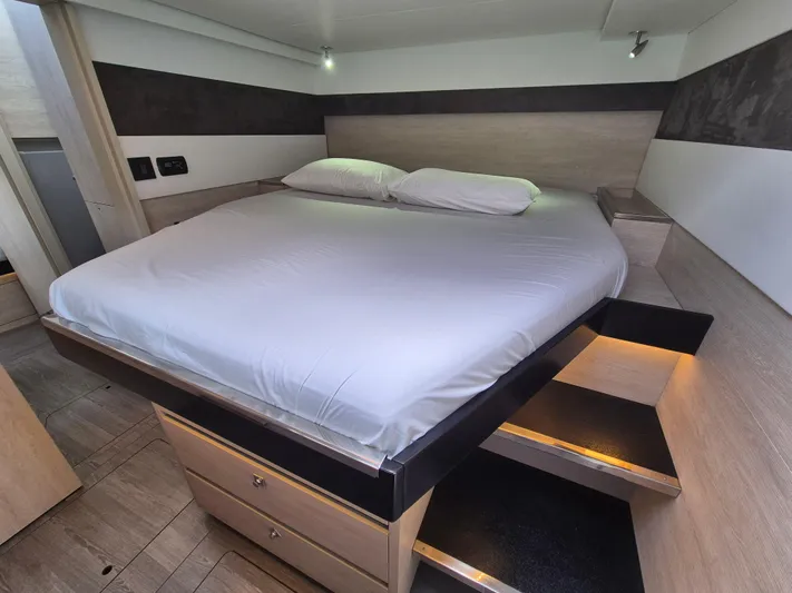 Takamaka Yacht Photos Pics Luxurious bedroom interior in a 2020 Leopard 50 yacht, featuring a cozy bed and modern design.