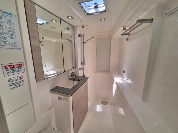 Takamaka Yacht Photos Pics Modern bathroom interior in a 2020 Leopard 50 yacht, featuring sleek design and skylight.