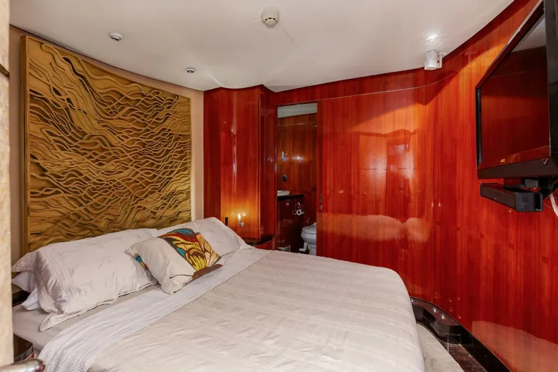 Patron Yacht Photos Pics Luxurious bedroom in 2004 Custom Ebony Sportfish 65' CNV yacht with wood paneling and modern decor.