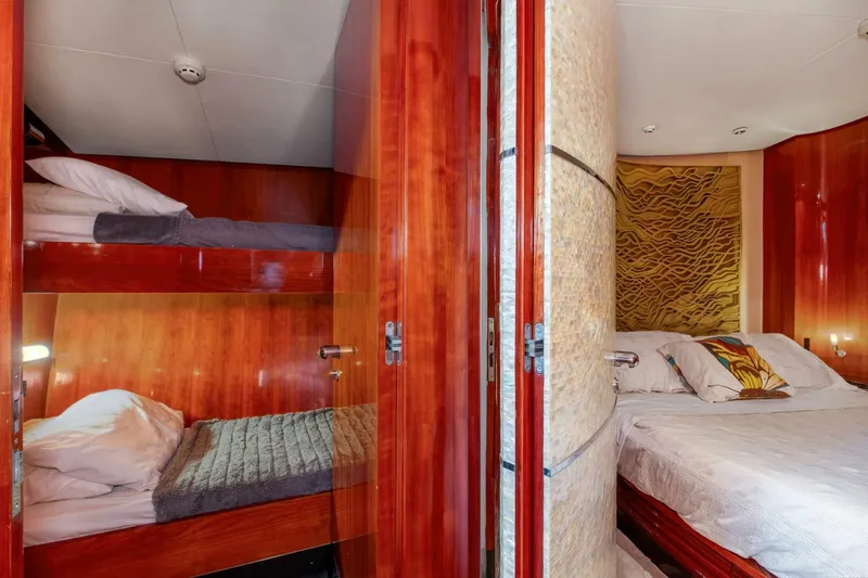 Patron Yacht Photos Pics Luxurious cabin interior of 2004 Custom Ebony Sportfish 65' CNV with wood paneling and cozy beds.