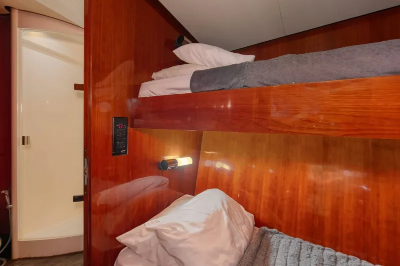 Patron Yacht Photos Pics Bunk beds in a 2004 Custom Ebony Sportfish 65' CNV yacht cabin with wood paneling.
