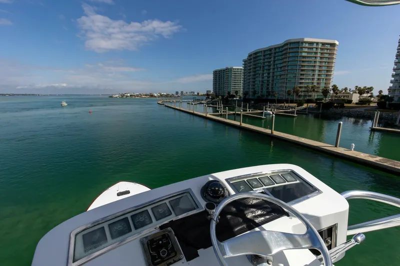 Patron Yacht Photos Pics Custom Ebony Sportfish 65' CNV 2004 yacht overlooking marina and waterfront buildings.