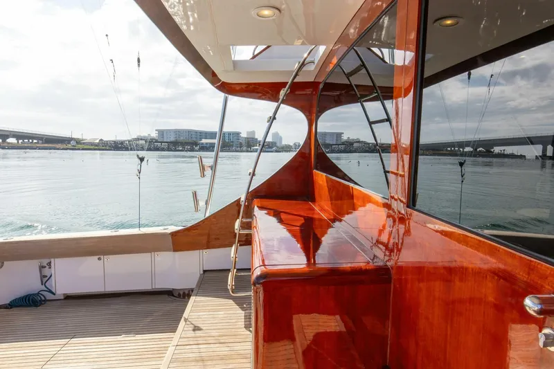 Patron Yacht Photos Pics Custom Ebony Sportfish 65' CNV yacht, 2004, with polished wood finish, docked by the water.